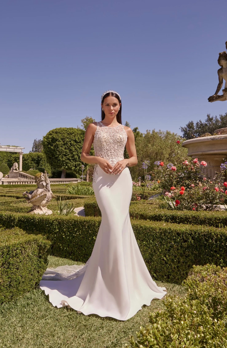 Model is wearing a georgette fit and flare bridal gown with beading and embroidery on an illusion neckline and bodice