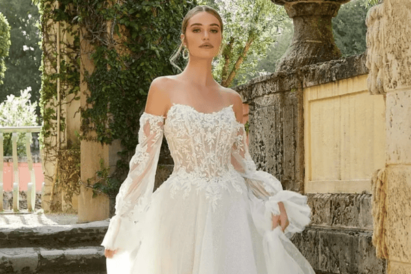 A bride in her off the shoulder wedding dress posing for the camera