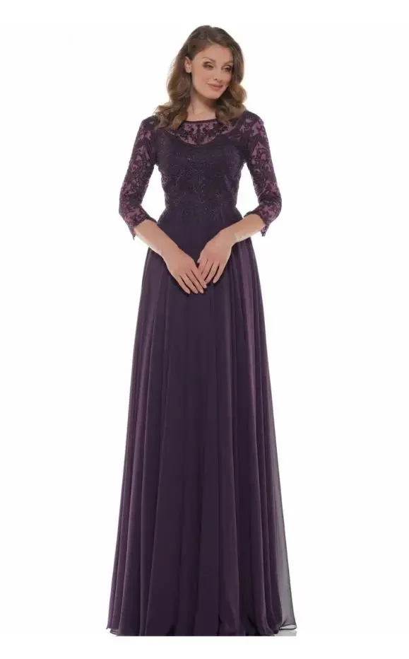 Woman wearing a plum-colored mother-of-the-bride gown with lace bodice, three-quarter sleeves, and a flowing chiffon skirt, posing against a white background.
