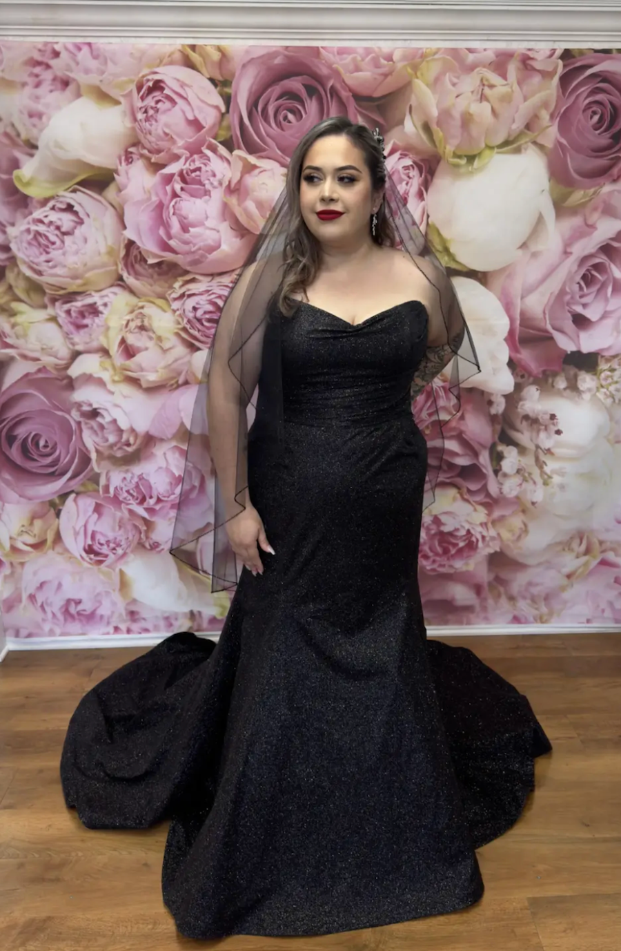 model is wearing a strapless mermaid black gown