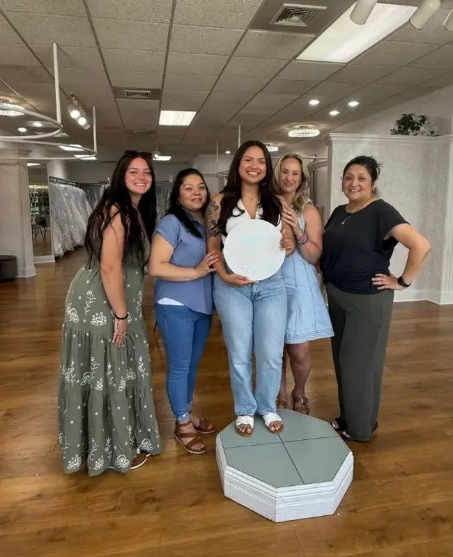Bride celebrating finding her dress with her family at Elegance Wedding and Evening Wear