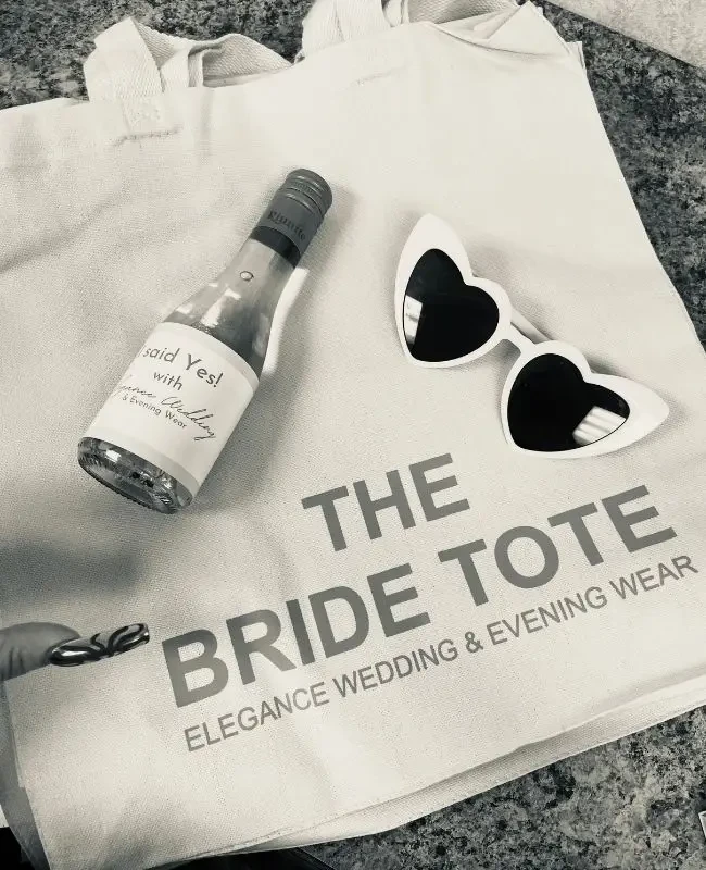 The Bride Tote from Elegance Wedding and Evening Wear, with champagne and heart-shaped sunglasses